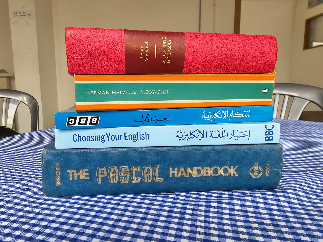 A stack of books on a checked tablecloth