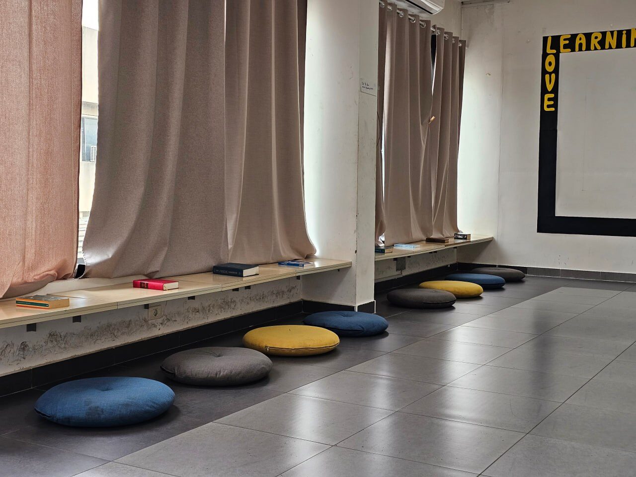 Floor cushions and books along the window bench, ready for a reflection session