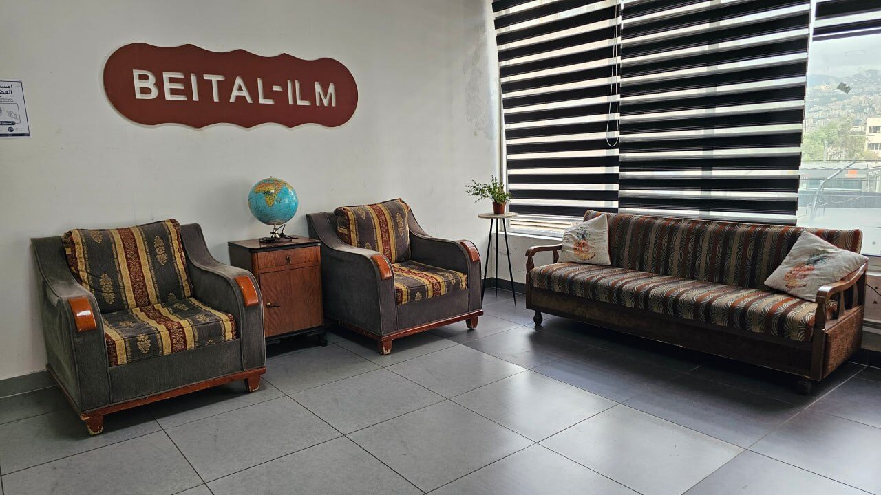The Beit Al-Ilm lounge, with armchairs, a globe and the Beit Al-Ilm sign on the wall