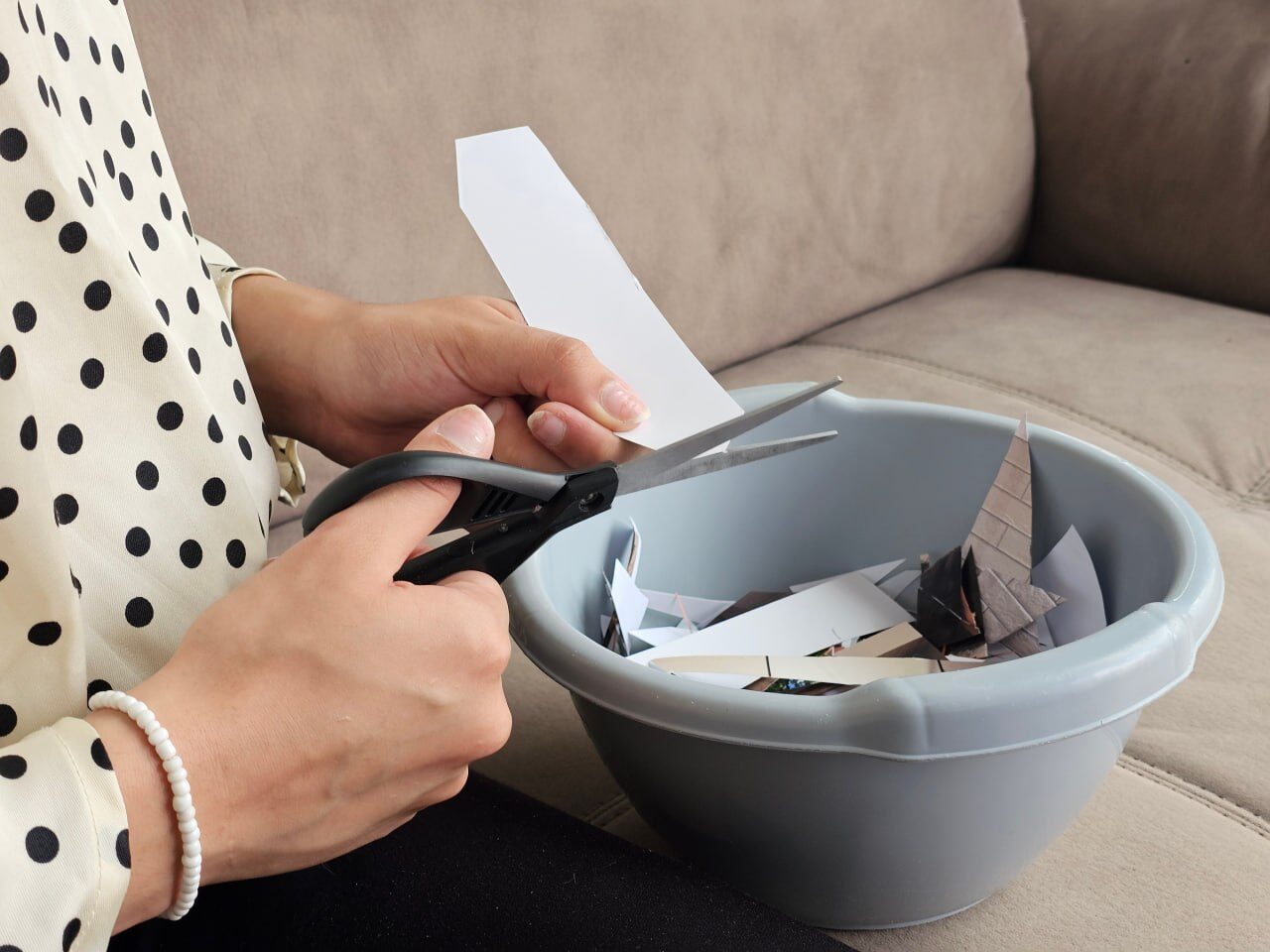 Hands cutting paper into a bowl during a hands-on activity